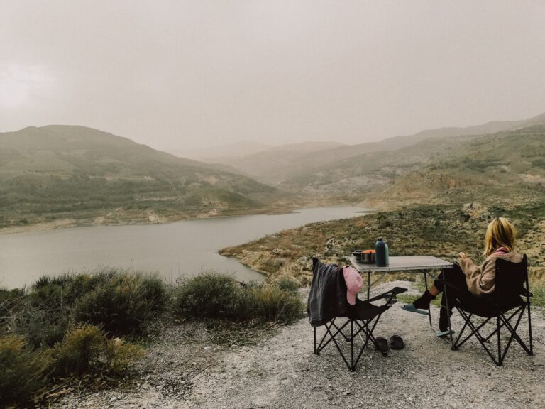 a couple of people sitting at a table on top of a hill